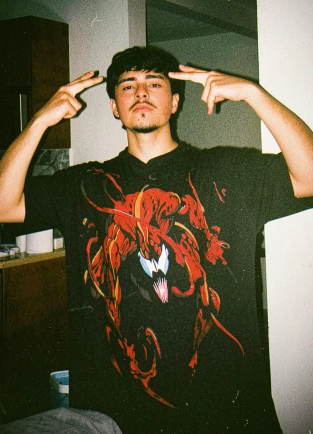 Candid Young Man in Carnage Graphic T-Shirt with Pointing Gestures in Vintage Flash Photography
