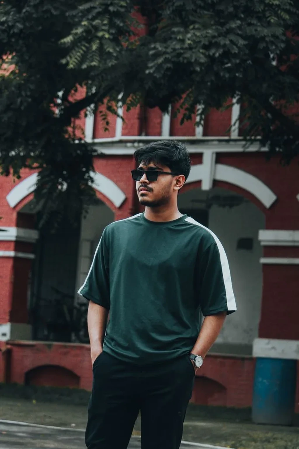 Urban Male Street Portrait in Oversized Green Tee by Heritage Building