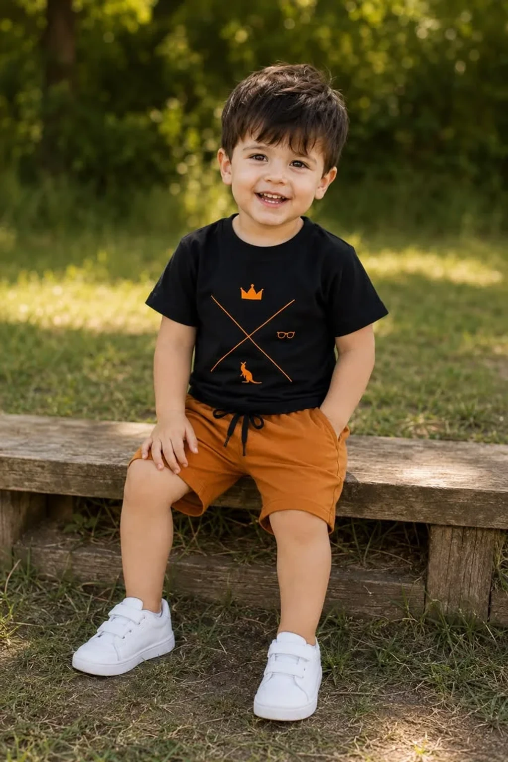 Candid Outdoor Portrait of Smiling Toddler Boy Seated on Wooden Bench