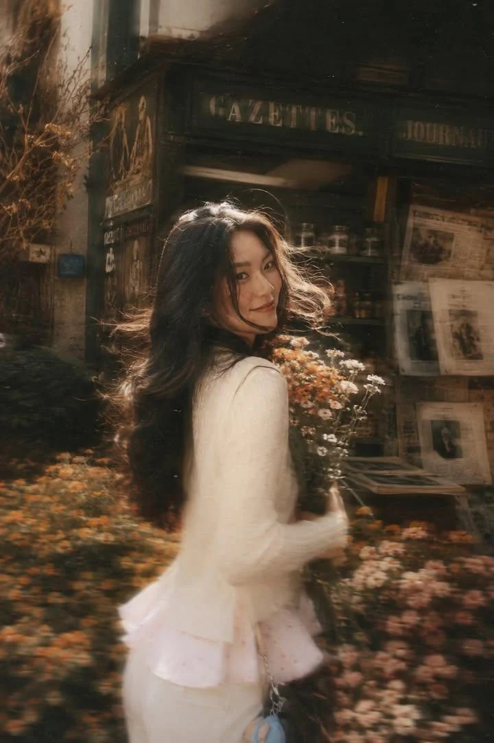 A Beautiful Young Woman with Long Dark Flowing Hair Holding a Bouquet of Soft Pink